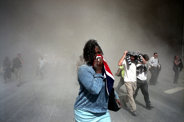USA. NYC. 9/11/2001. People use masks made out of clothing to protect themselves from dust that is thick in the air after the collpase of the World Trade Center towers. MAGNUM/Gilles Peress